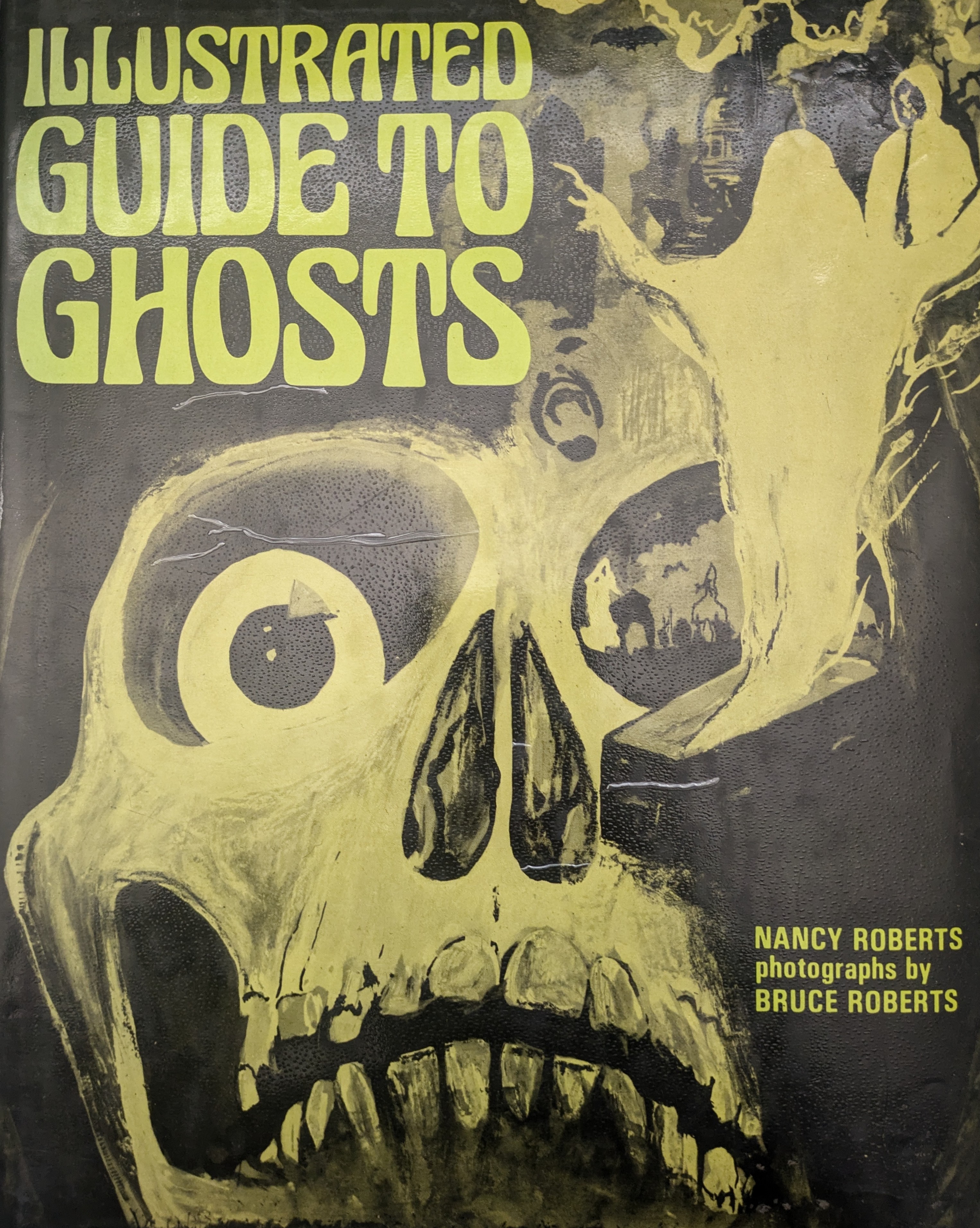 Book with skull and ghost illustrations titled Illustrated Guide to Ghosts by Nancy Roberts with photographs by Bruce Roberts