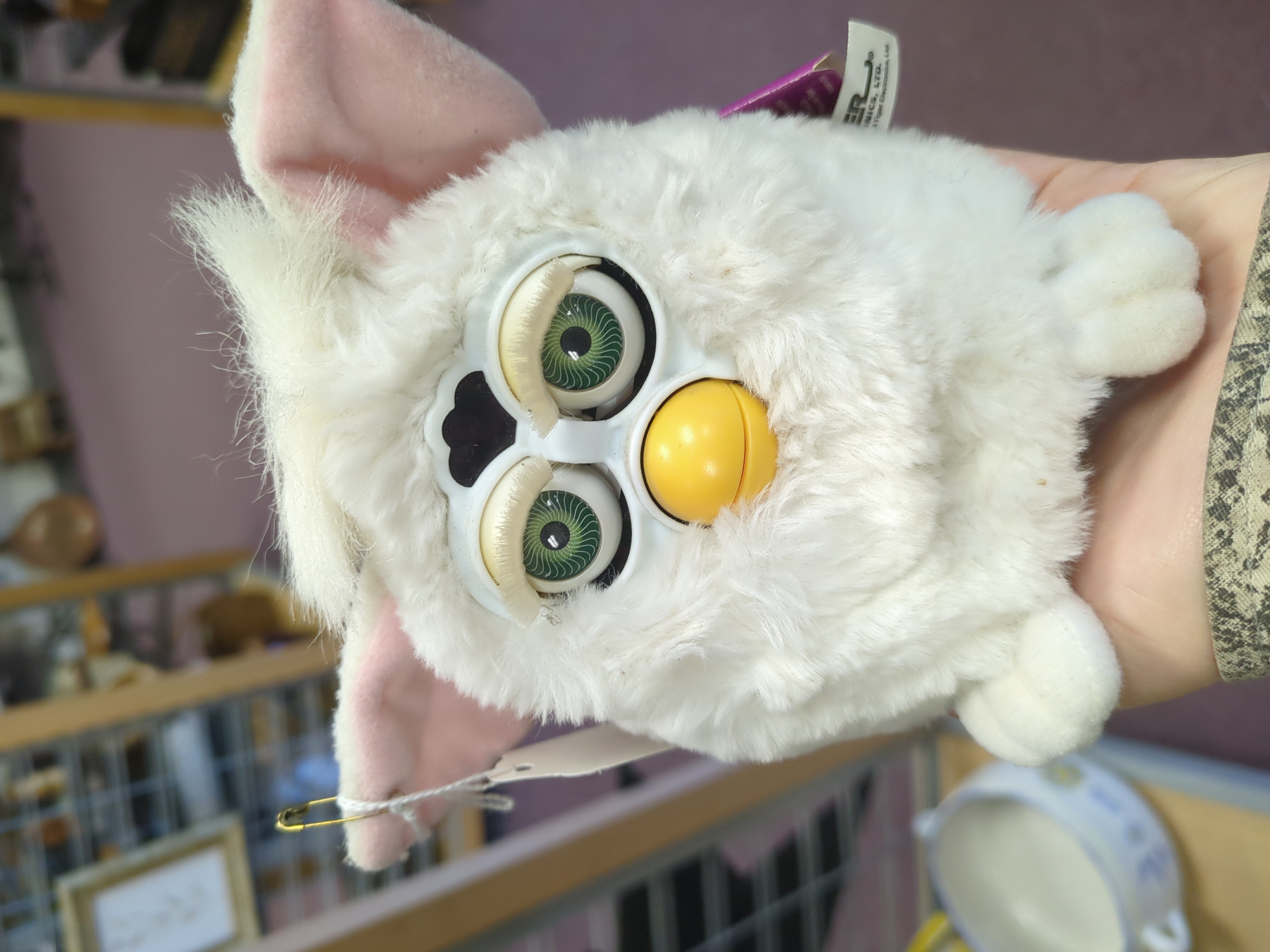 white Furby held in hand